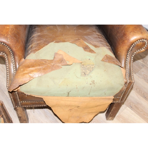 102 - A matched pair of antique style Chesterfield tan leather wingback club chairs for restoration