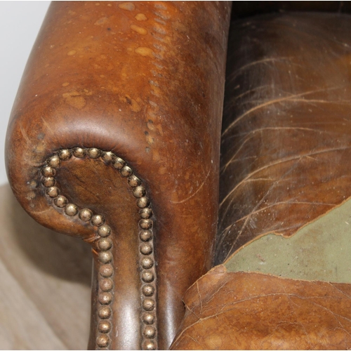 102 - A matched pair of antique style Chesterfield tan leather wingback club chairs for restoration