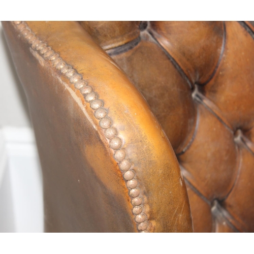 102 - A matched pair of antique style Chesterfield tan leather wingback club chairs for restoration