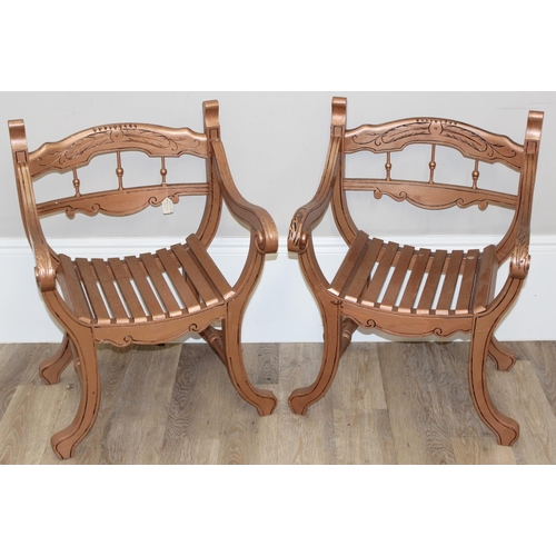 69 - A pair of rose gold painted Savonarola shaped armchairs with carved details, each approx 58cm wide x... 