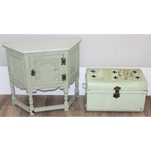 101 - A vintage side cupboard of trapezium form with carved details and a vintage metal travelling trunk, ... 