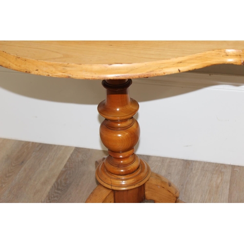 90 - An antique light wood veneered tilt topped table on tripod base, approx 102cm wide x 72cm deep x 70c... 