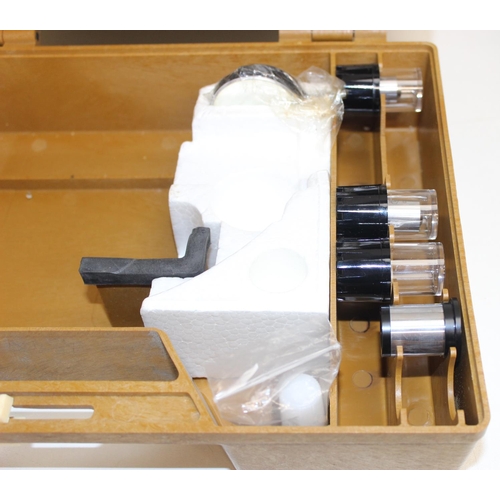 763 - A vintage Olympus microscope in hard shell travel case, with various accessories