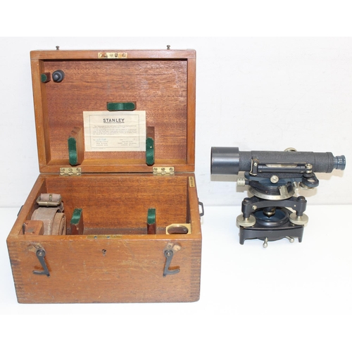 770 - A vintage Stanley theodolite in wooden case with leather strap and other accessories