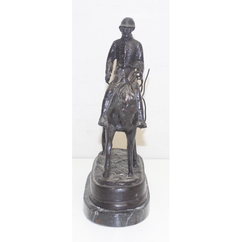 1688 - A 20th century bronze figure of a polo player on horse presented on a black marble base, seemingly u... 