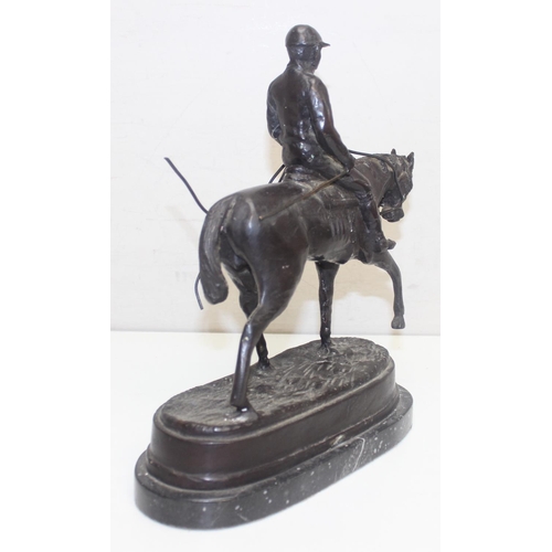 1688 - A 20th century bronze figure of a polo player on horse presented on a black marble base, seemingly u... 