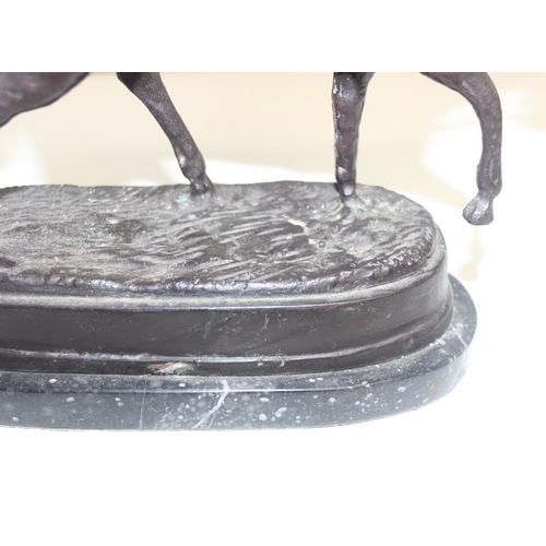 1688 - A 20th century bronze figure of a polo player on horse presented on a black marble base, seemingly u... 