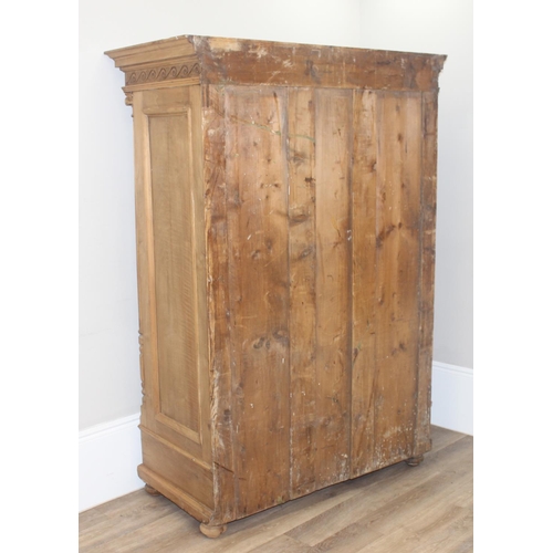 30 - A large impressive antique wardrobe with profusely carved details and ionic column supports, 2 doors... 