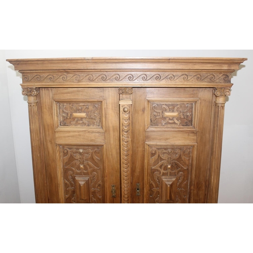 30 - A large impressive antique wardrobe with profusely carved details and ionic column supports, 2 doors... 