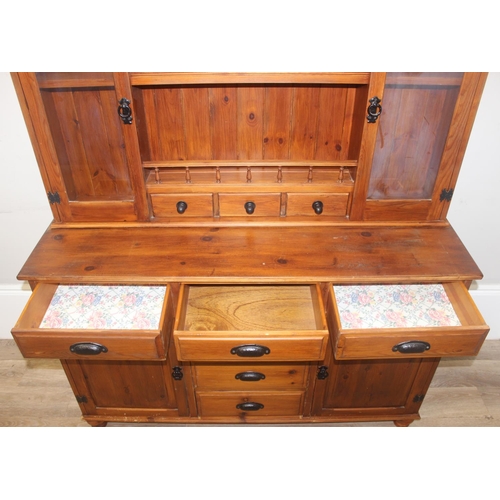 26 - A modern pine dresser, the base with 4 central drawers flanked by a drawer over a cupboard, the top ... 