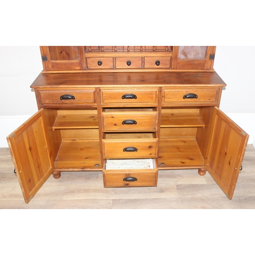 26 - A modern pine dresser, the base with 4 central drawers flanked by a drawer over a cupboard, the top ... 