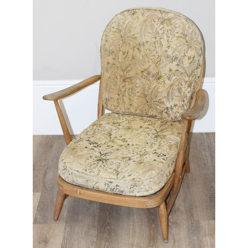 10 - Ercol - a retro low backed armchair with mid-century floral cushions, believed to be a model 334 fro... 