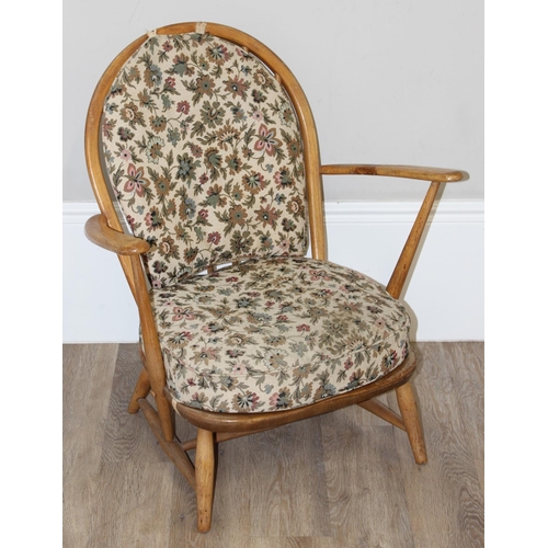 11 - Ercol - a retro low backed armchair with mid-century floral cushions, believed to be a model 334 fro... 