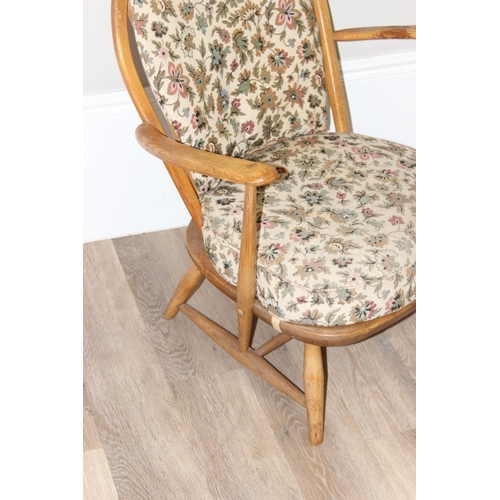 11 - Ercol - a retro low backed armchair with mid-century floral cushions, believed to be a model 334 fro... 