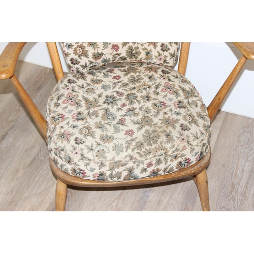 11 - Ercol - a retro low backed armchair with mid-century floral cushions, believed to be a model 334 fro... 