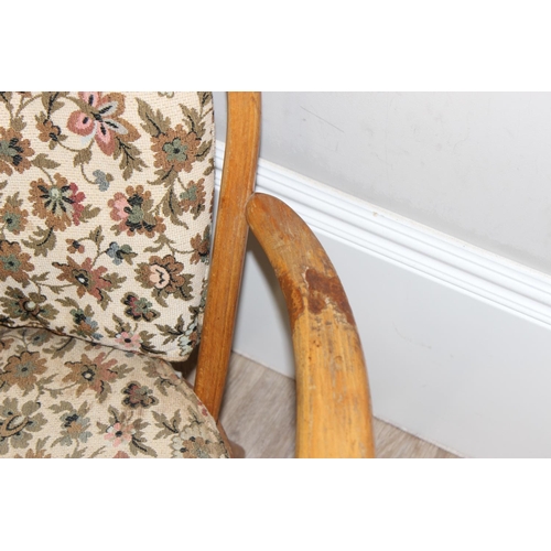 11 - Ercol - a retro low backed armchair with mid-century floral cushions, believed to be a model 334 fro... 