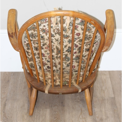 11 - Ercol - a retro low backed armchair with mid-century floral cushions, believed to be a model 334 fro... 