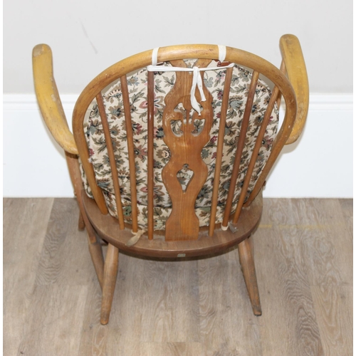 12 - Ercol - a retro low backed armchair with mid-century floral cushions, fleur-de-lys slat back, light ... 