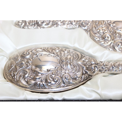 1047 - A boxed Sterling silver mounted 3 piece dressing table set comprising of a hand mirror, a hair brush... 