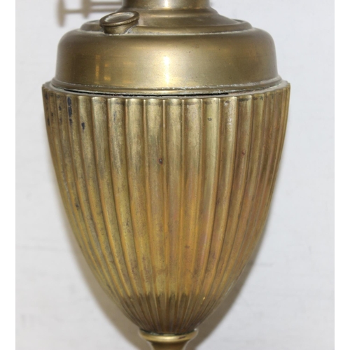 248 - An antique gilt metal oil lamp with black glazed pottery base, white glass shade and glass chimney, ... 