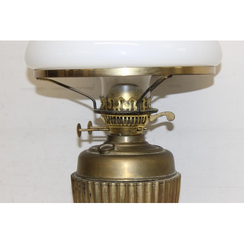 248 - An antique gilt metal oil lamp with black glazed pottery base, white glass shade and glass chimney, ... 