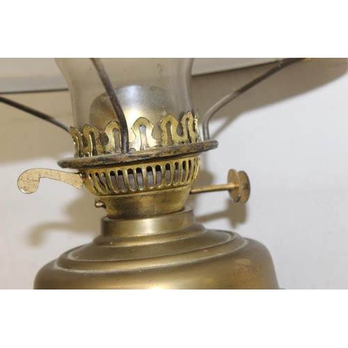 248 - An antique gilt metal oil lamp with black glazed pottery base, white glass shade and glass chimney, ... 