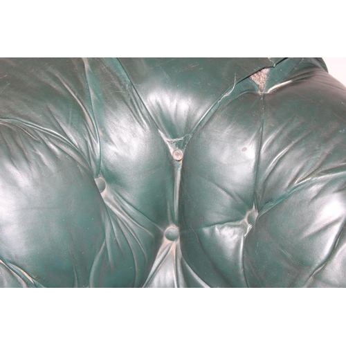 66 - An antique green leather horsehair stuffed Chesterfield button back sofa, 2 seater with mahogany leg... 