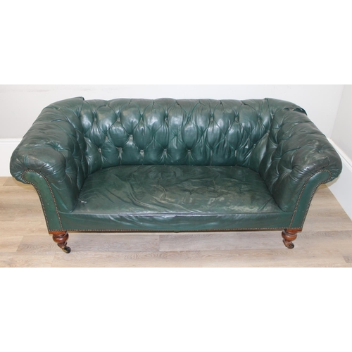 66 - An antique green leather horsehair stuffed Chesterfield button back sofa, 2 seater with mahogany leg... 