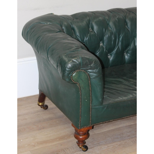 66 - An antique green leather horsehair stuffed Chesterfield button back sofa, 2 seater with mahogany leg... 