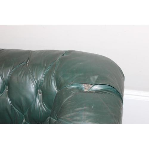 66 - An antique green leather horsehair stuffed Chesterfield button back sofa, 2 seater with mahogany leg... 