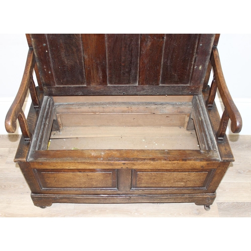 140 - An antique oak monk's bench or settle on castors, pegged joints with lift up seat, approx 115cm x 59... 