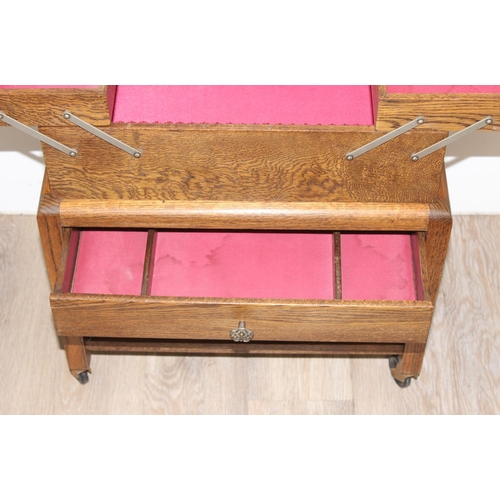 314 - An Art Deco period oak concertina sewing box on wheels, approx 50cm wide when closed