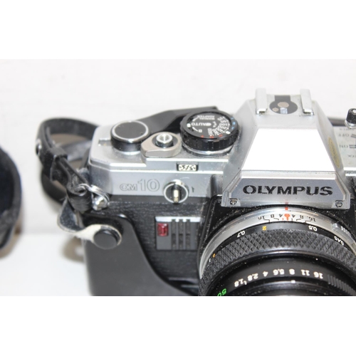 779 - A vintage Olympus OM10 SLR camera with 2 lenses and paperwork, the lenses being a Miranda 70-210mm 1... 