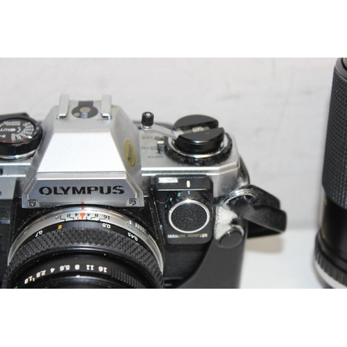 779 - A vintage Olympus OM10 SLR camera with 2 lenses and paperwork, the lenses being a Miranda 70-210mm 1... 