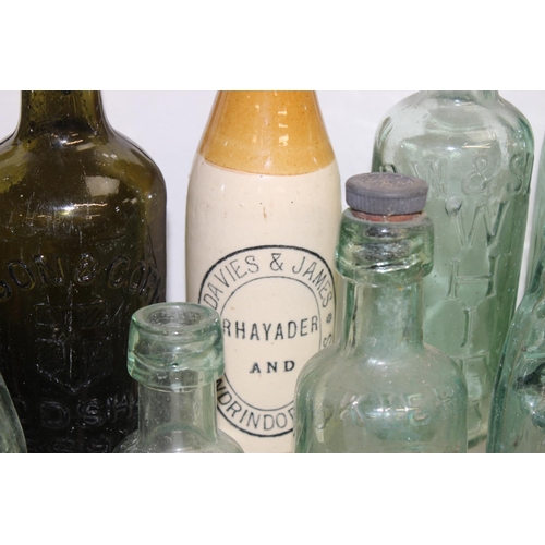 1657 - Qty of assorted antique and later glass and pottery bottles, many advertising, and some with local i... 