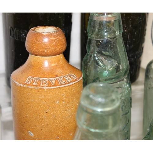 1657 - Qty of assorted antique and later glass and pottery bottles, many advertising, and some with local i... 