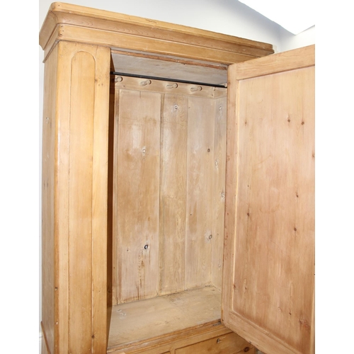 109 - A Victorian pine wardrobe with 2 drawer base, the top with both rail and pegs to interior, 2 origina... 