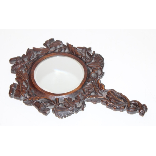 1486 - An antique Black Forest carved wooden hand mirror decorated with oak leaves and acorns, approx 35cm ... 