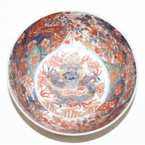 1487 - An antique Chinese or Japanese porcelain bowl with Imari colours, the centre decorated with a dragon... 