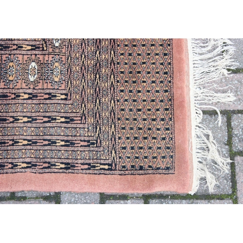 214 - A very large salmon ground rug, approx 293cm x 380cm