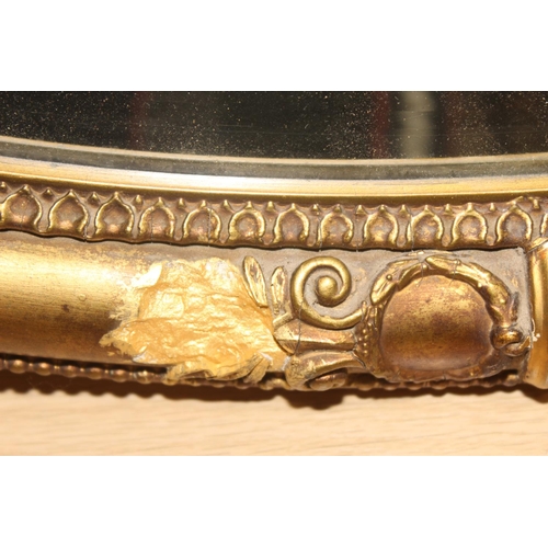 459B - An antique gilt framed oval shaped wall mirror, approx 83cm x 57cm