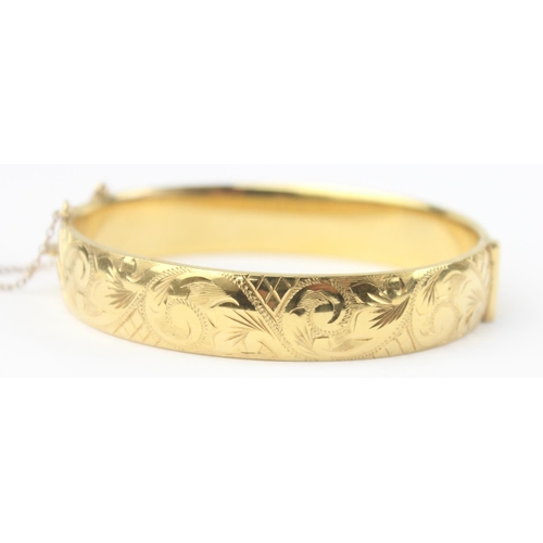 1123 - A vintage 9ct gold with metal core bangle with engraved decoration, marked 9ct gold metal cored and ... 