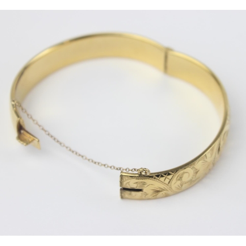 1123 - A vintage 9ct gold with metal core bangle with engraved decoration, marked 9ct gold metal cored and ... 