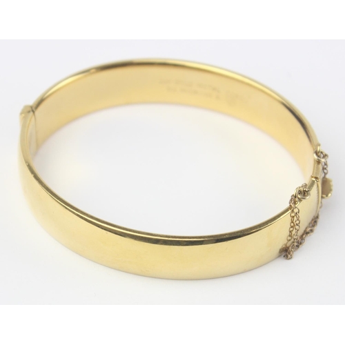 1123 - A vintage 9ct gold with metal core bangle with engraved decoration, marked 9ct gold metal cored and ... 