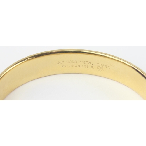 1123 - A vintage 9ct gold with metal core bangle with engraved decoration, marked 9ct gold metal cored and ... 