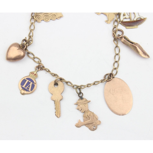 1154 - A vintage 9ct gold charm bracelet with a number of 9ct gold charms, some with enamel, to include tra... 