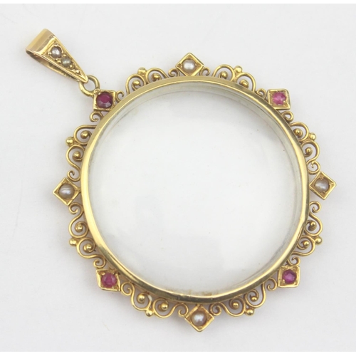 1157 - An antique yellow metal pendant locket set with seed pearls and rubies within a filigree border, see... 