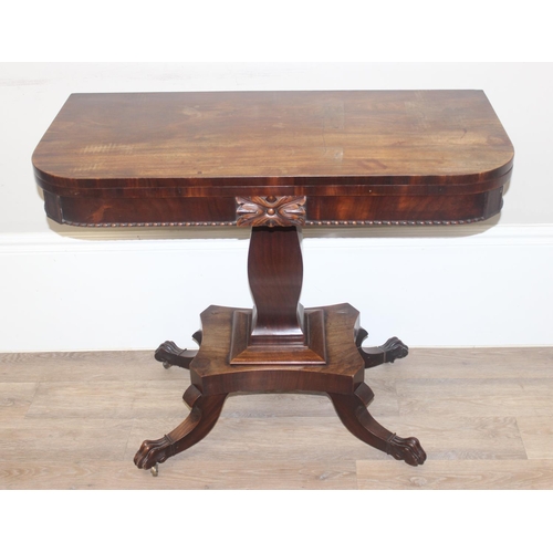 33 - A 19th century rosewood tea table with fold over top and lion paw feet on pillar base, approx 92cm w... 