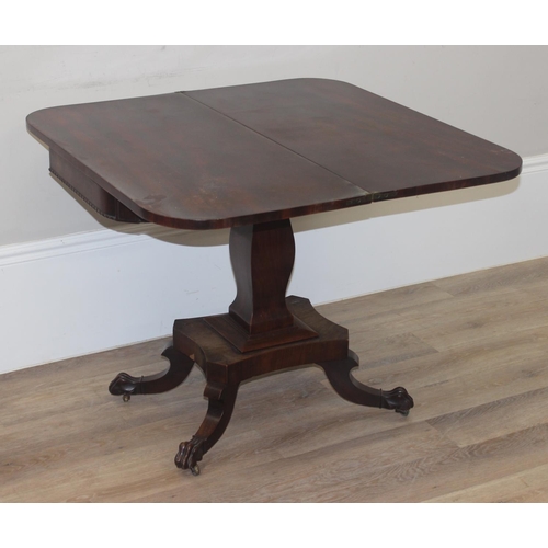 33 - A 19th century rosewood tea table with fold over top and lion paw feet on pillar base, approx 92cm w... 