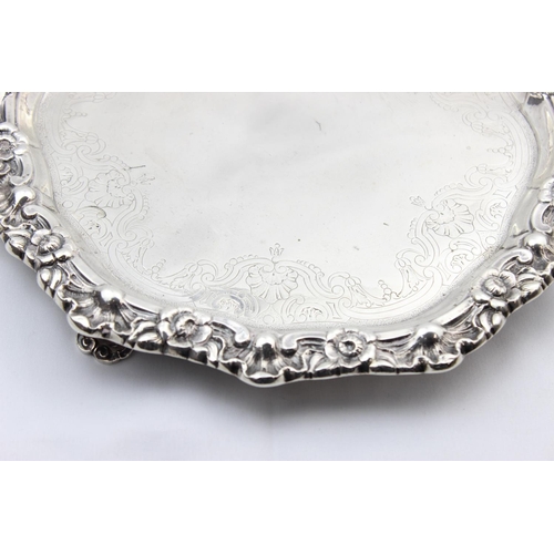 1064 - A large silver card tray with engraved decoration and floral cast border, indistinctly marked but XR... 